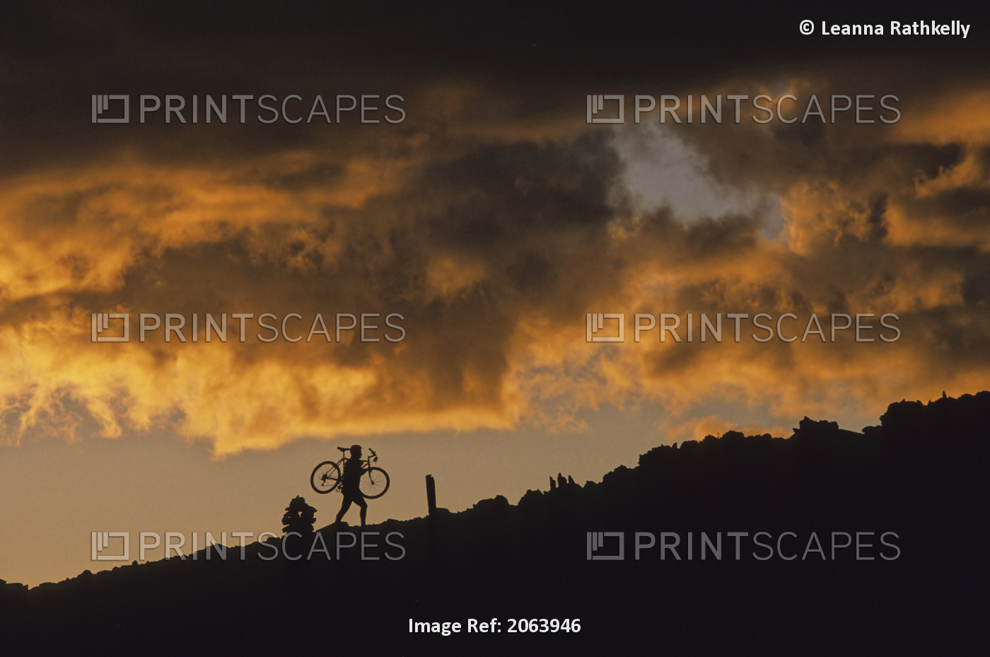 Mountain Biker Carries Bike Up Rocky Slope, Sunset Clouds Behind, Whistler, Bc ...