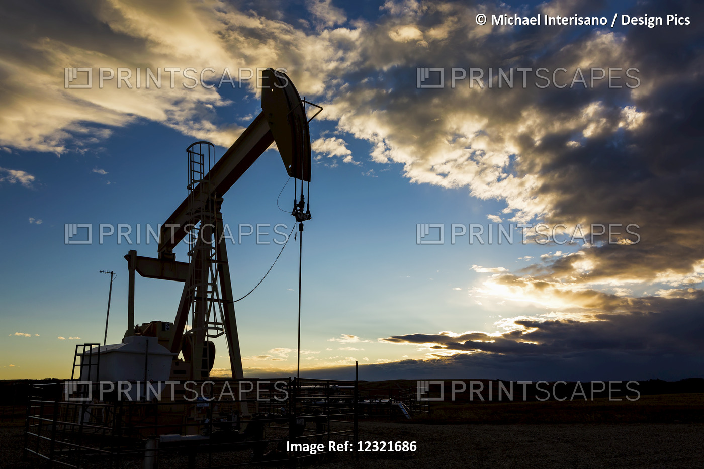Silhouette Of Pump Jack With Dramatic Storm Clouds And Blue Sky; Alberta, Canada