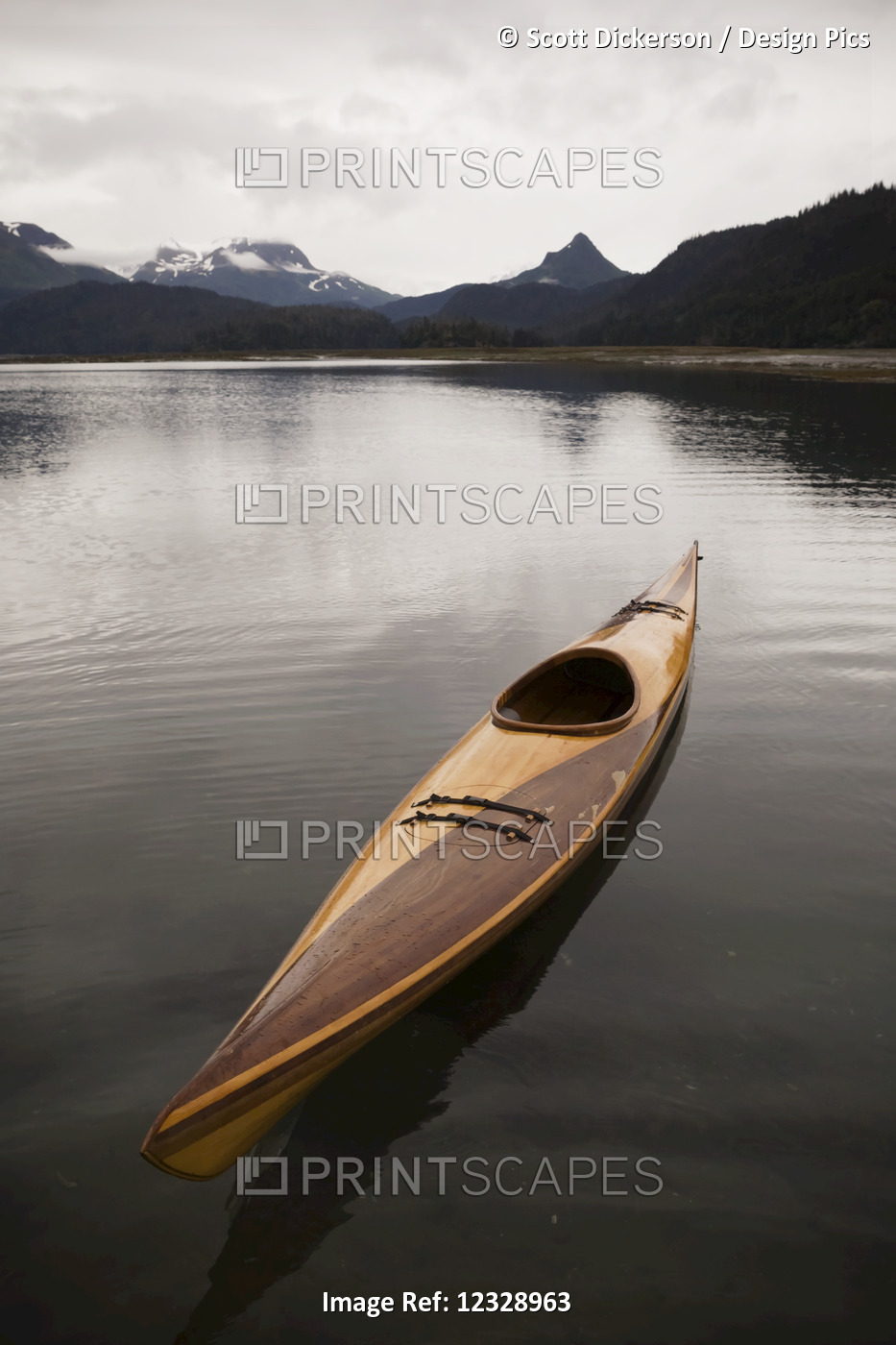 A Wooden Kayak Sits On Tranquil Water With A View Of The Mountains In The ...