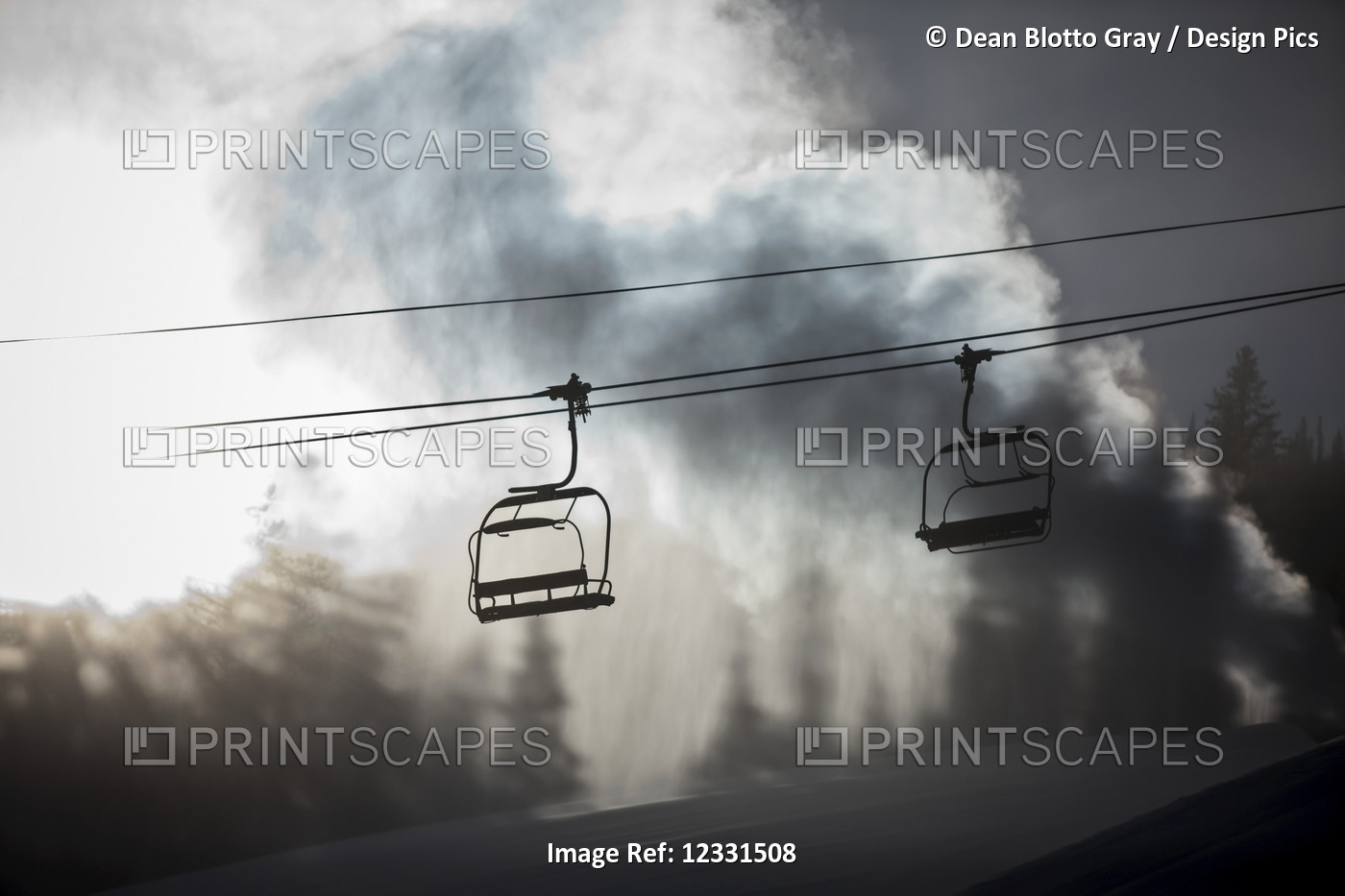 Silhouette of a chairlift on a ski hill with man made snow from  snow gun ...