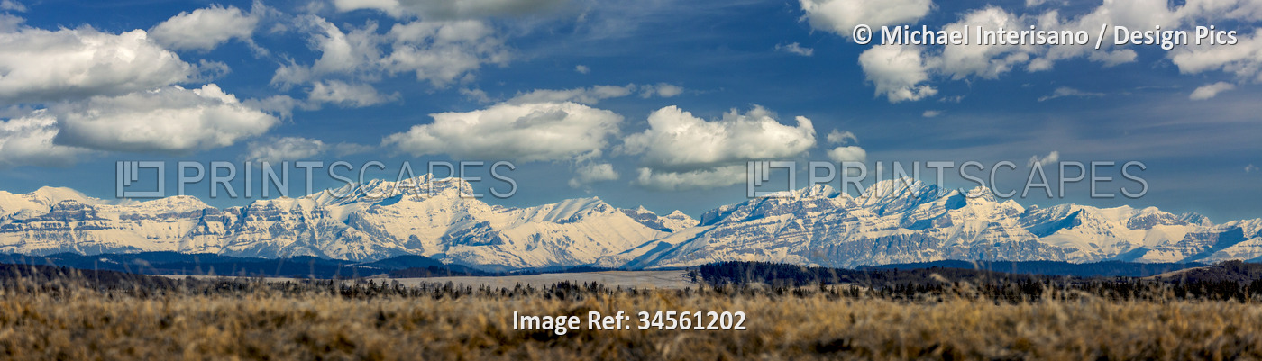 Panorama snow-covered mountain range with blue sky and fluffy clouds, West of ...